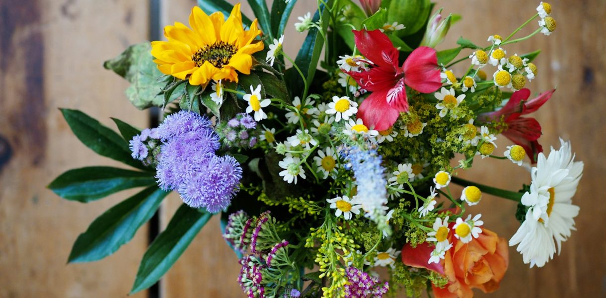 assorted-color flowers on brown wood